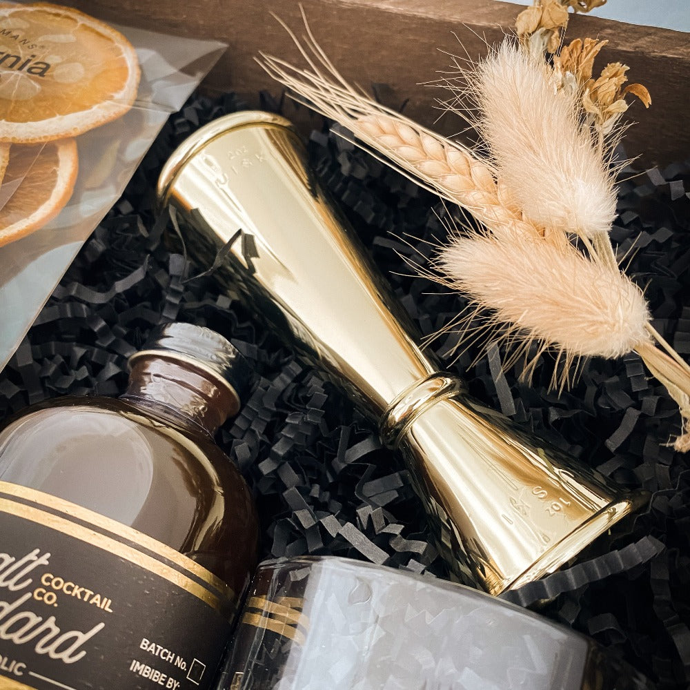 Old Fashioned Drink Luxury Gift box with 2 Crystal tumblers, a Viski gold jigger, Pratt Standard Cocktail Co. Old Fashioned Syrup, Orange Crisps and a gold mixing spoon.
