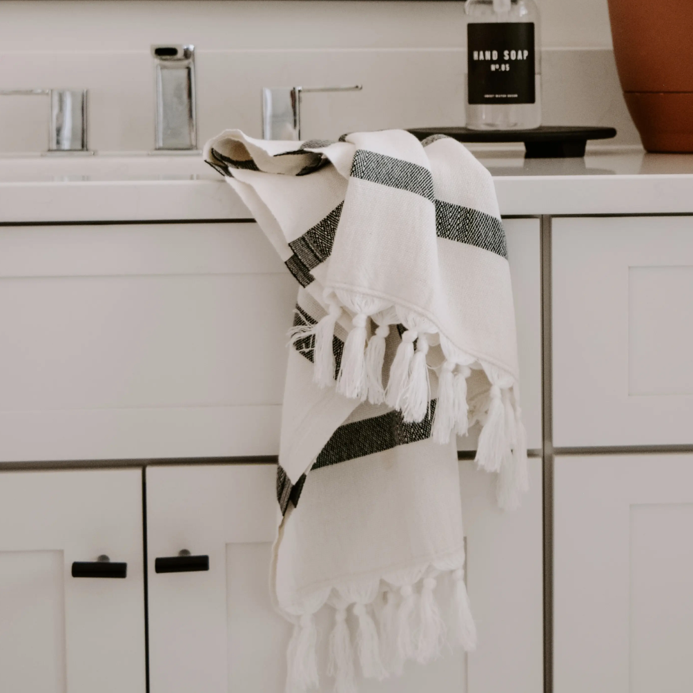 White & black-striped kitchen towel with tassels from Sweet Water Home Decor